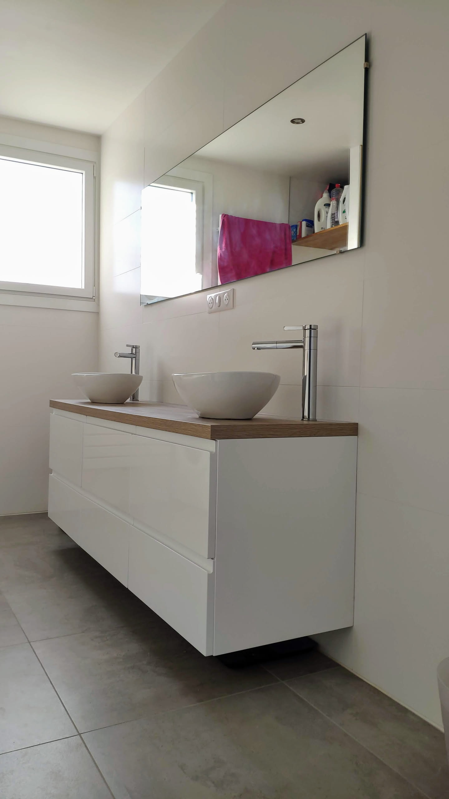 Vue complète de la salle de bain montrant baignoire, machine à laver et sèche-serviettes